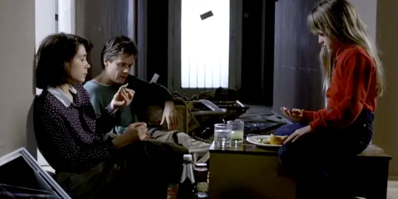 A scene from the movie The Seventh Continent showing the family sitting among wrecked possessions eating a snack and taking tablets